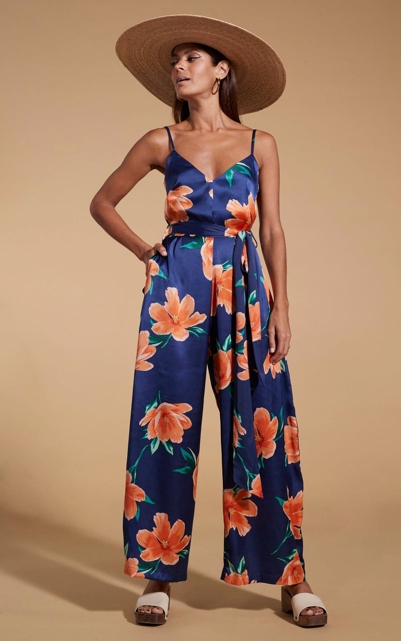 Dancing Leopard model wearing Gabriella Jumpsuit in Orange on Navy Blue Tulip posed with hand in pocket