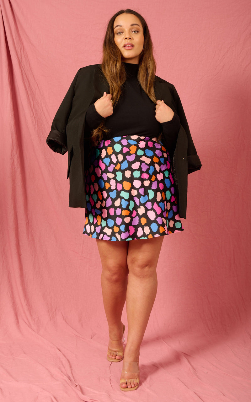Dancing Leopard model wearing Stevie Mini Skirt in Multi Cloud with black top and blazer over shoulders