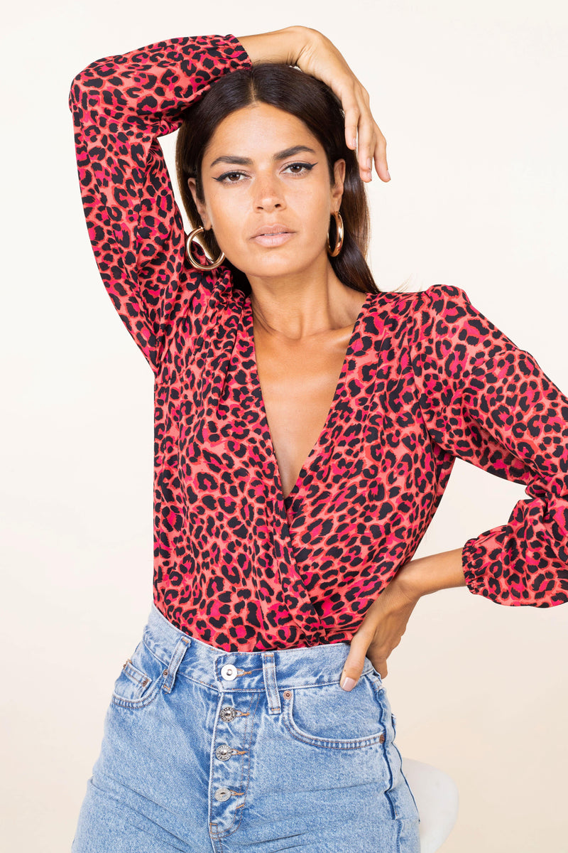 Dancing Leopard model faces forward wears Bixby Bodysuit In Ruby Red Leopard print with arm up