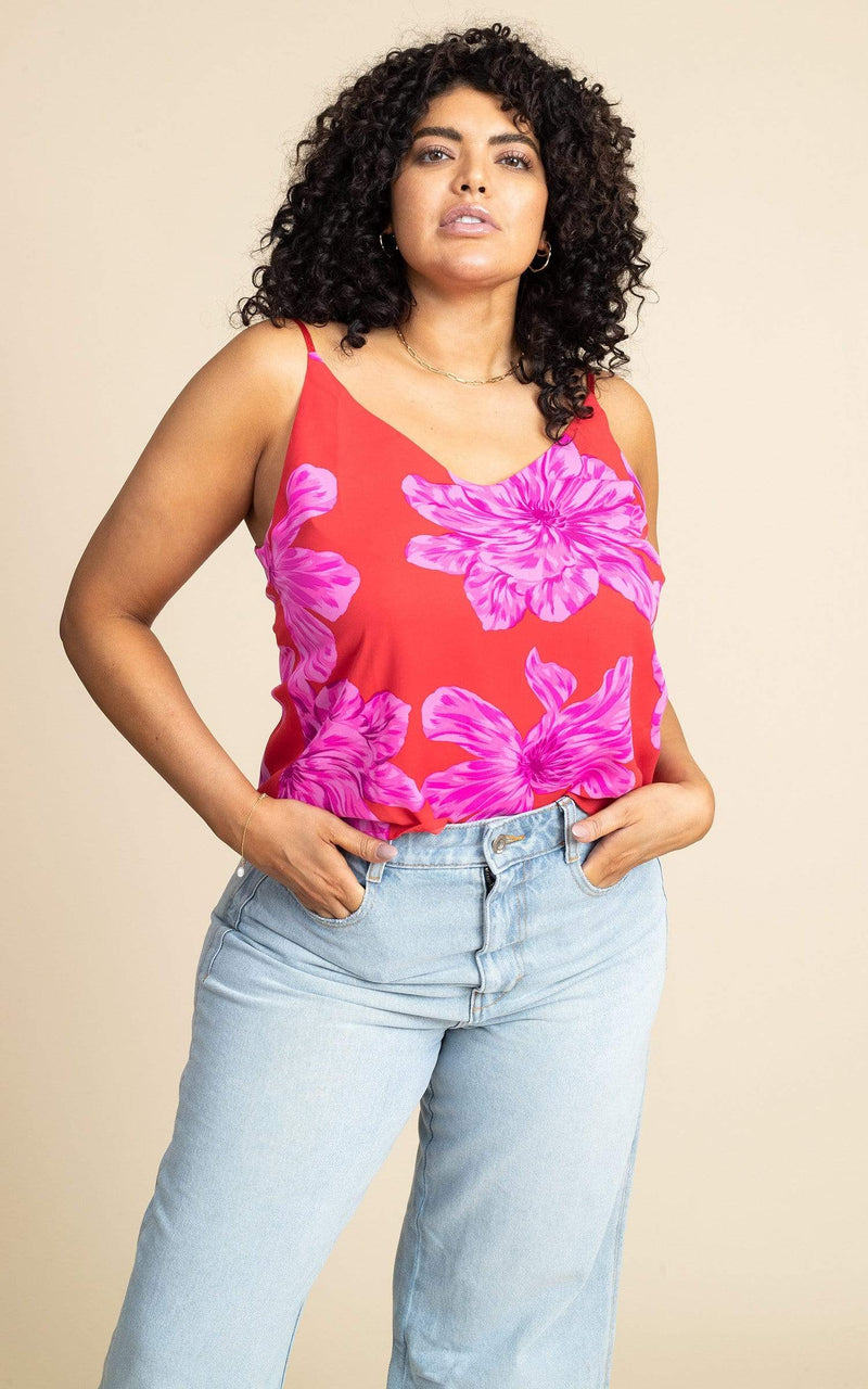 Dancing Leopard model wearing Birdie Cami in Pink on Red Bloom posing with hands in jeans pockets