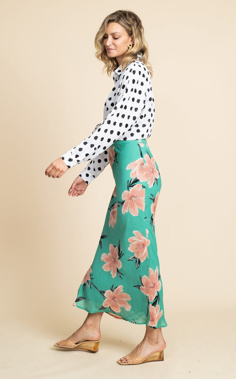 Dancing Leopard model faces side-on wears Sophie Skirt in green floral print with heeled sandals