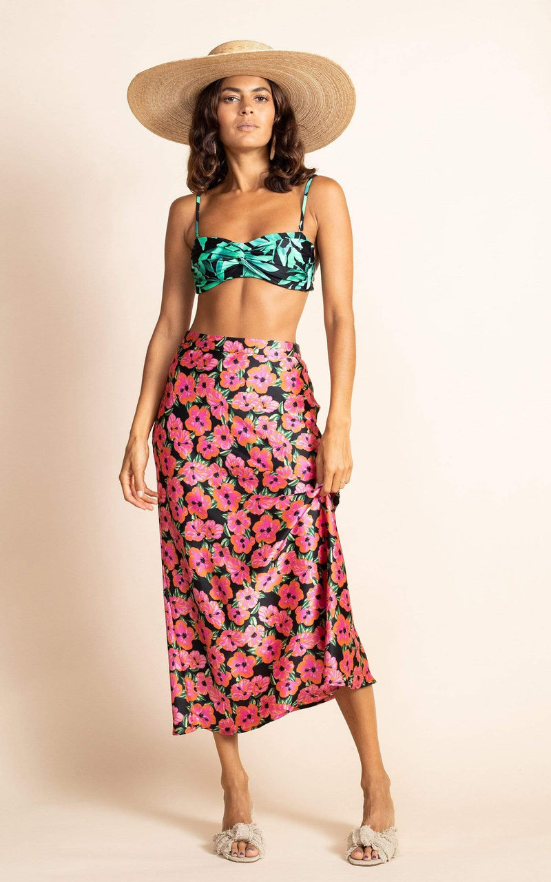 Dancing Leopard model faces forward wearing Renzo Skirt in floral print with bikini top and straw hat