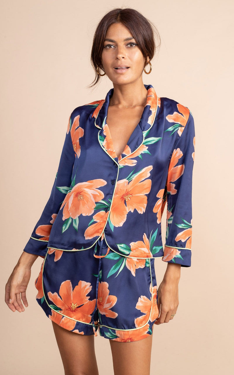 Dancing leopard model standing front to the camera with hands by her side wearing navy blue and orange tulip  print matching pyjamas set