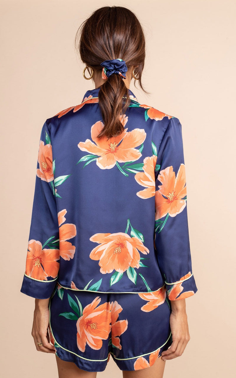 Dancing leopard model standing back  to the camera with hands by her side wearing navy blue and orange tulip  print matching pyjamas set