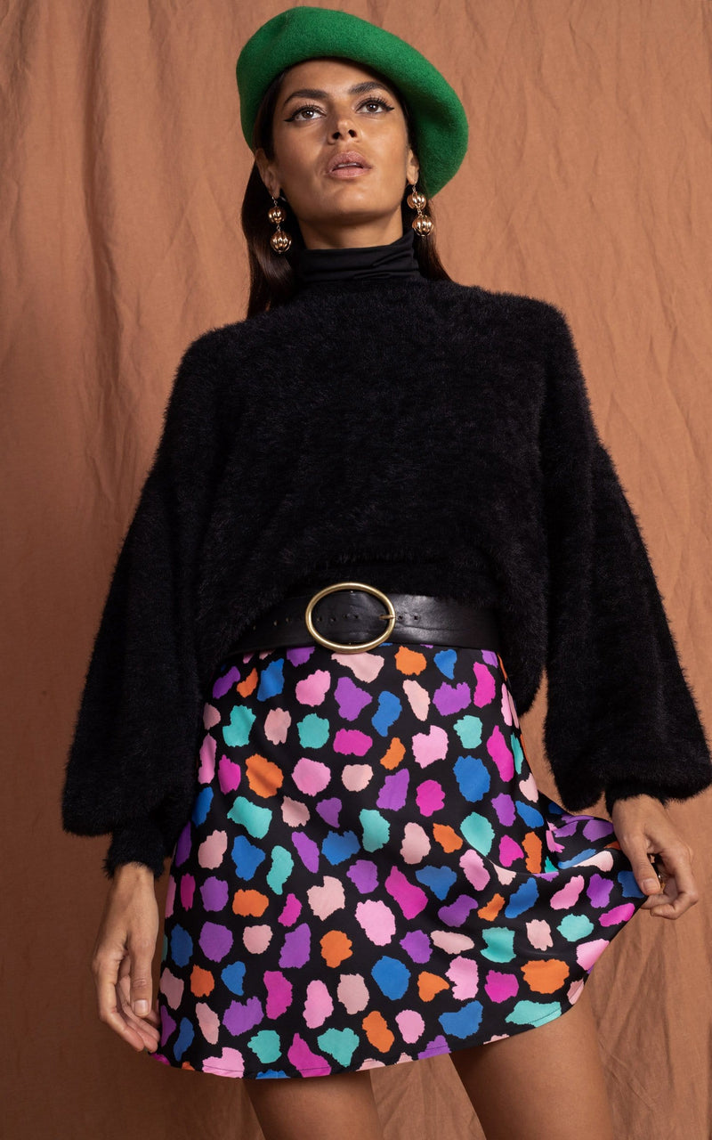 Dancing Leopard model close up faces forward wearing Stevie Skirt in multi cloud with fluffy jumper, green hat and boots