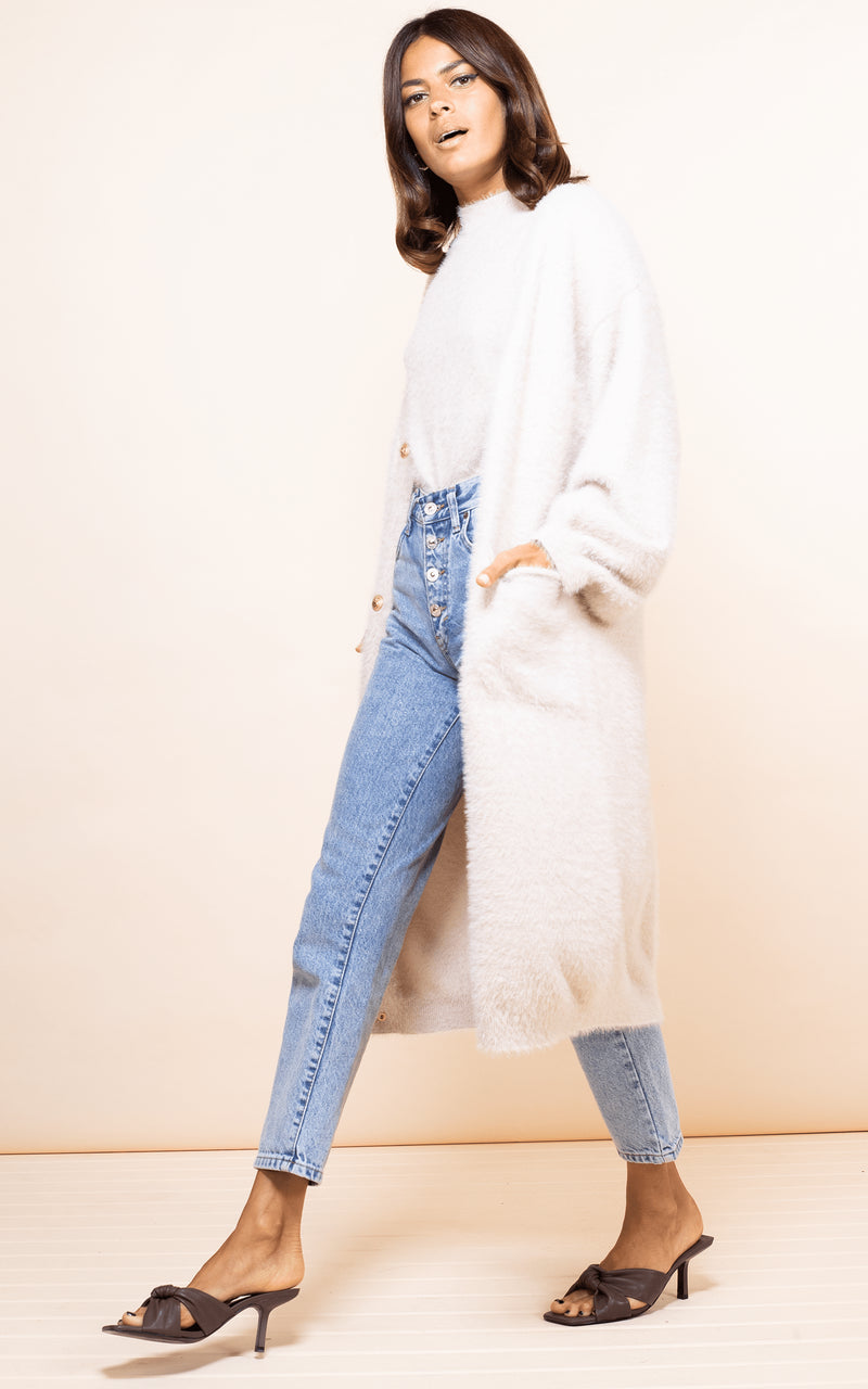 Dancing Leopard model walks forwards wearing Taylor Cardigan in nude with jeans