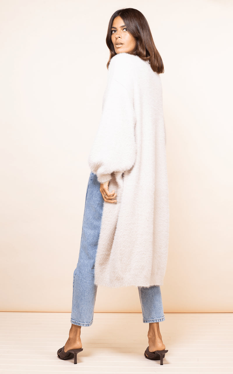 Dancing Leopard model faces backwards wearing Taylor Cardigan in nude with jeans