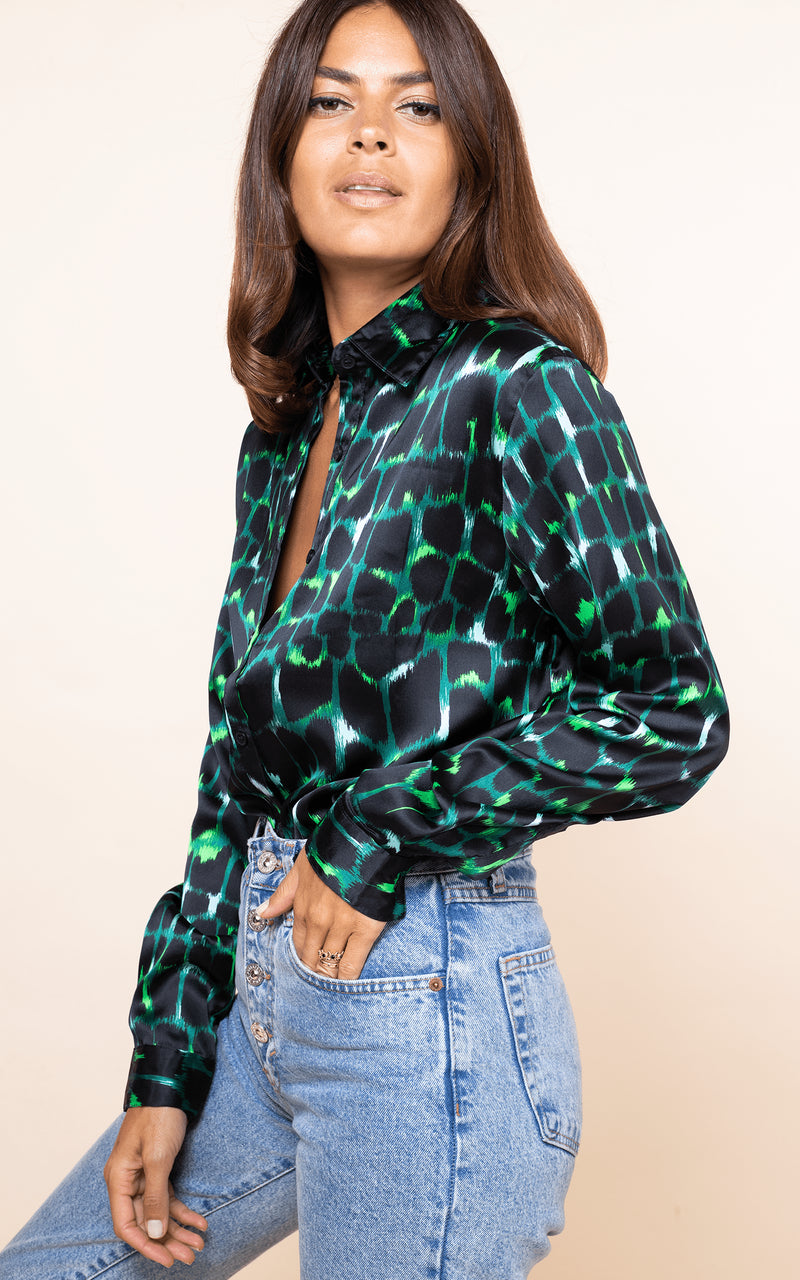 Dancing Leopard model faces sideways with hands in jeans pocket wearing San Diego Shirt in green alligator print