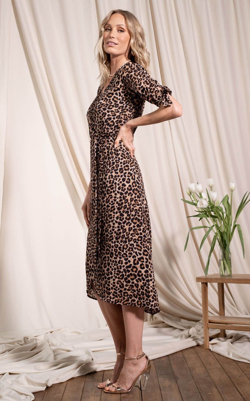 Dancing Leopard model standing sideways with hand on hip wearing Olivera midid dress in rich leopard