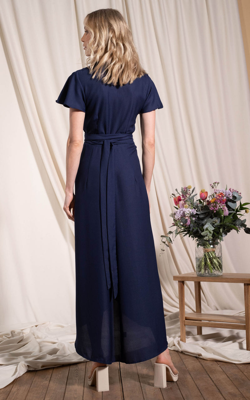 Dancing Leopard model standing with back to the camera wearing cayenne dress in navy
