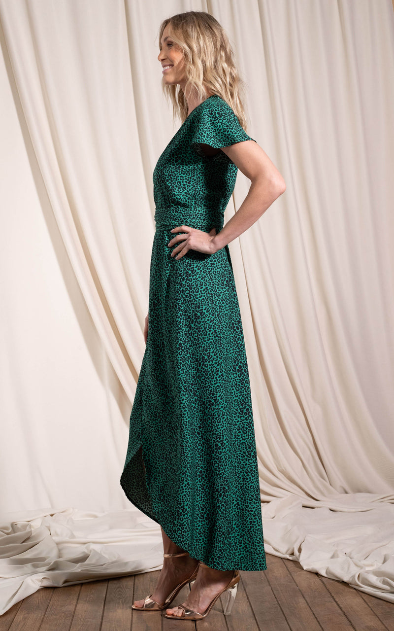 Dancing Leopard model standing sideways with hand on hip wearing Cayenne dress in small green leopard 