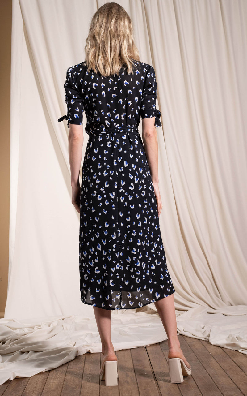 Dancing Leopard model standing with back to the camera wearing Olivera midi dress in abstract white on black leopard 