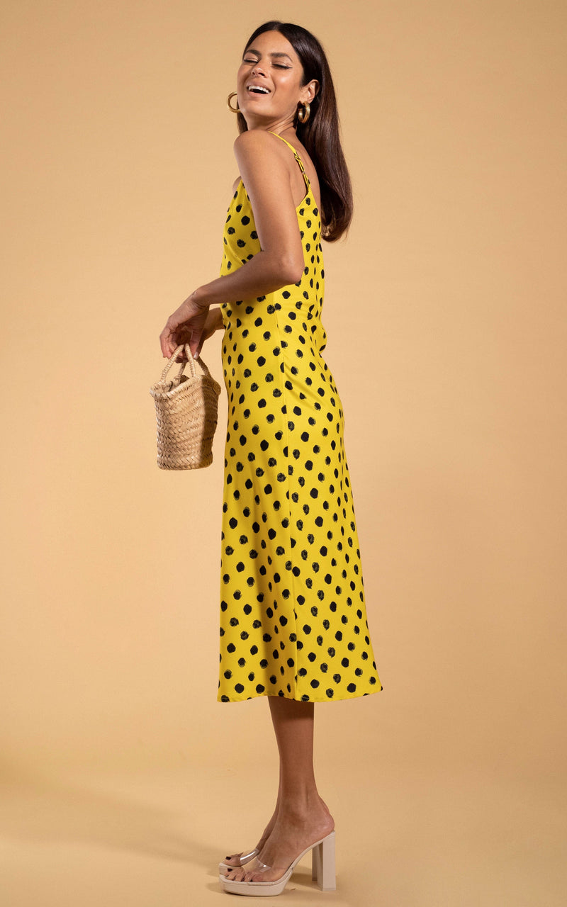 Dancing Leopard model standing sideways holding straw bag and laughing