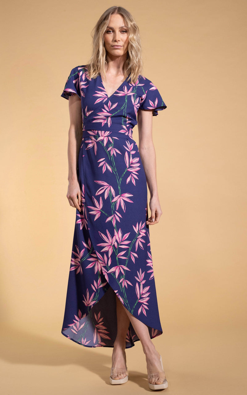 Dancing Leopard model standing with legs crossed wearing Cayenne midi wrap dress in bamboo navy base with clear heels 
