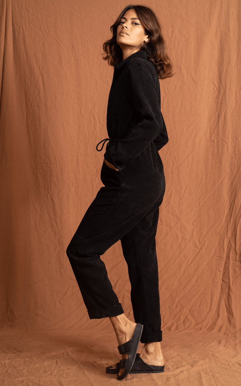 Dancing Leopard model faces side-on wearing Blaze Boilersuit in Black with sandals