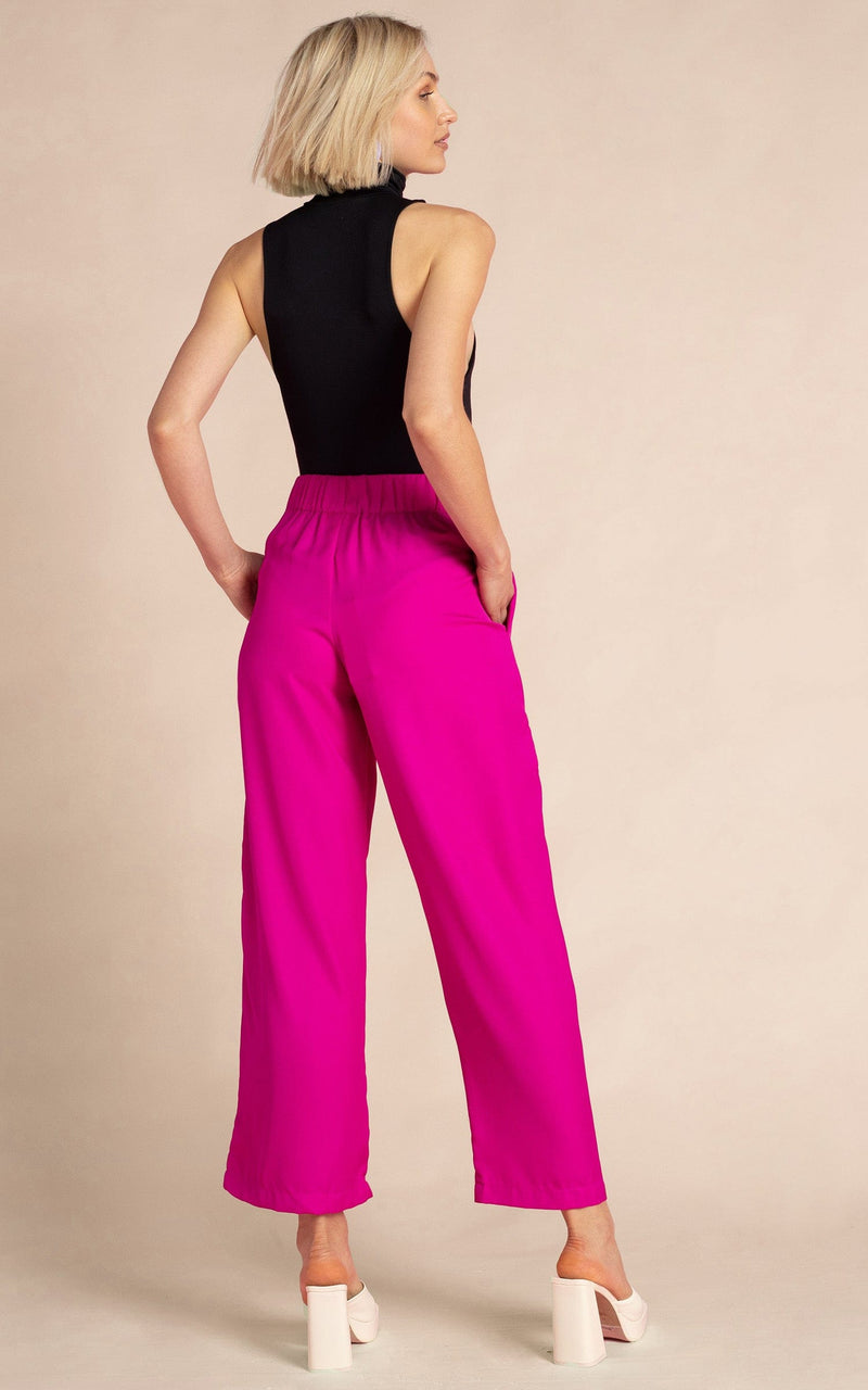 Dancing Leopard model wearing Joey Palazzo Trousers in Magenta facing away to show back of trousers