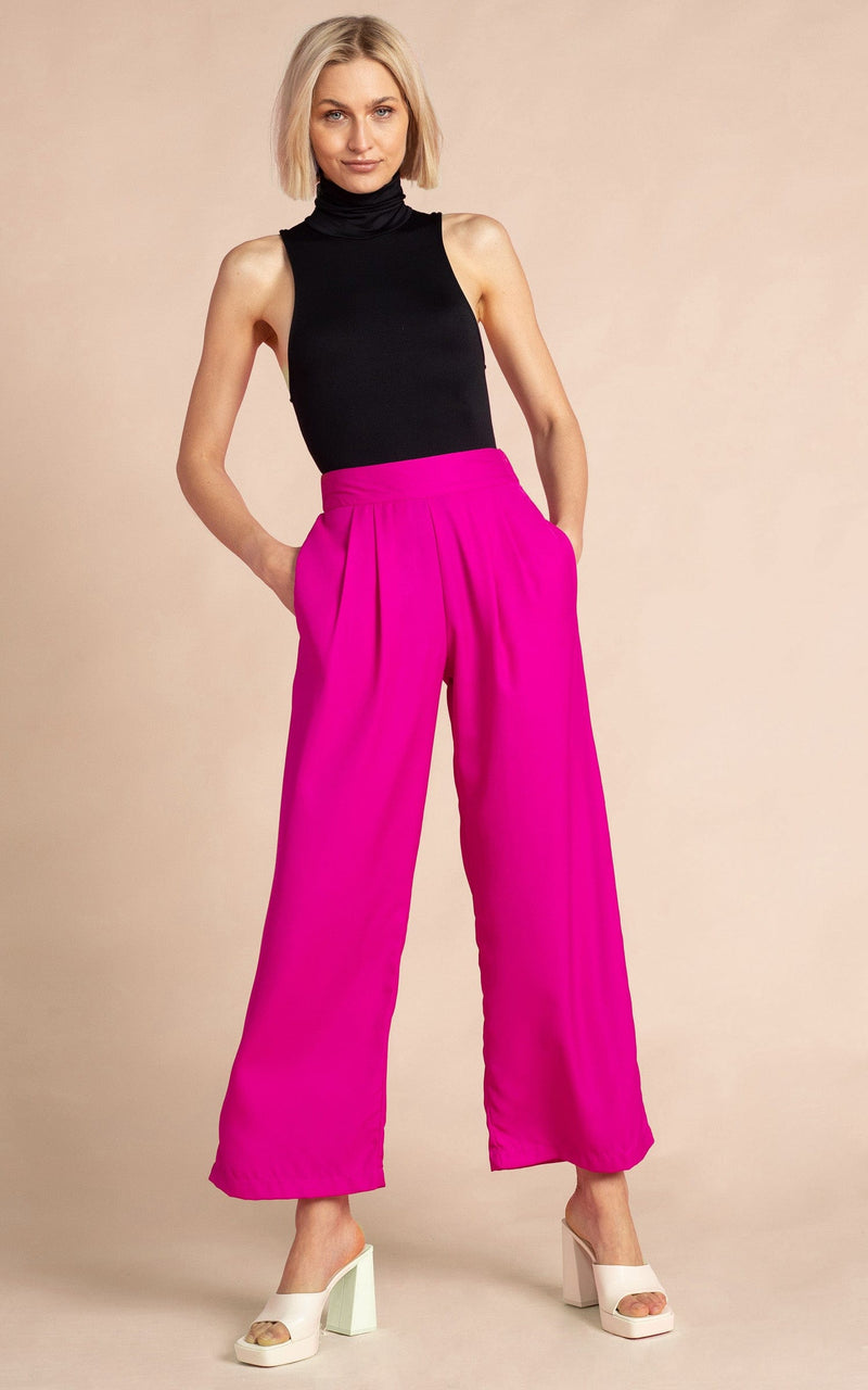 Dancing Leopard model wearing Joey Palazzo Trousers in Magenta posed with hands in pockets