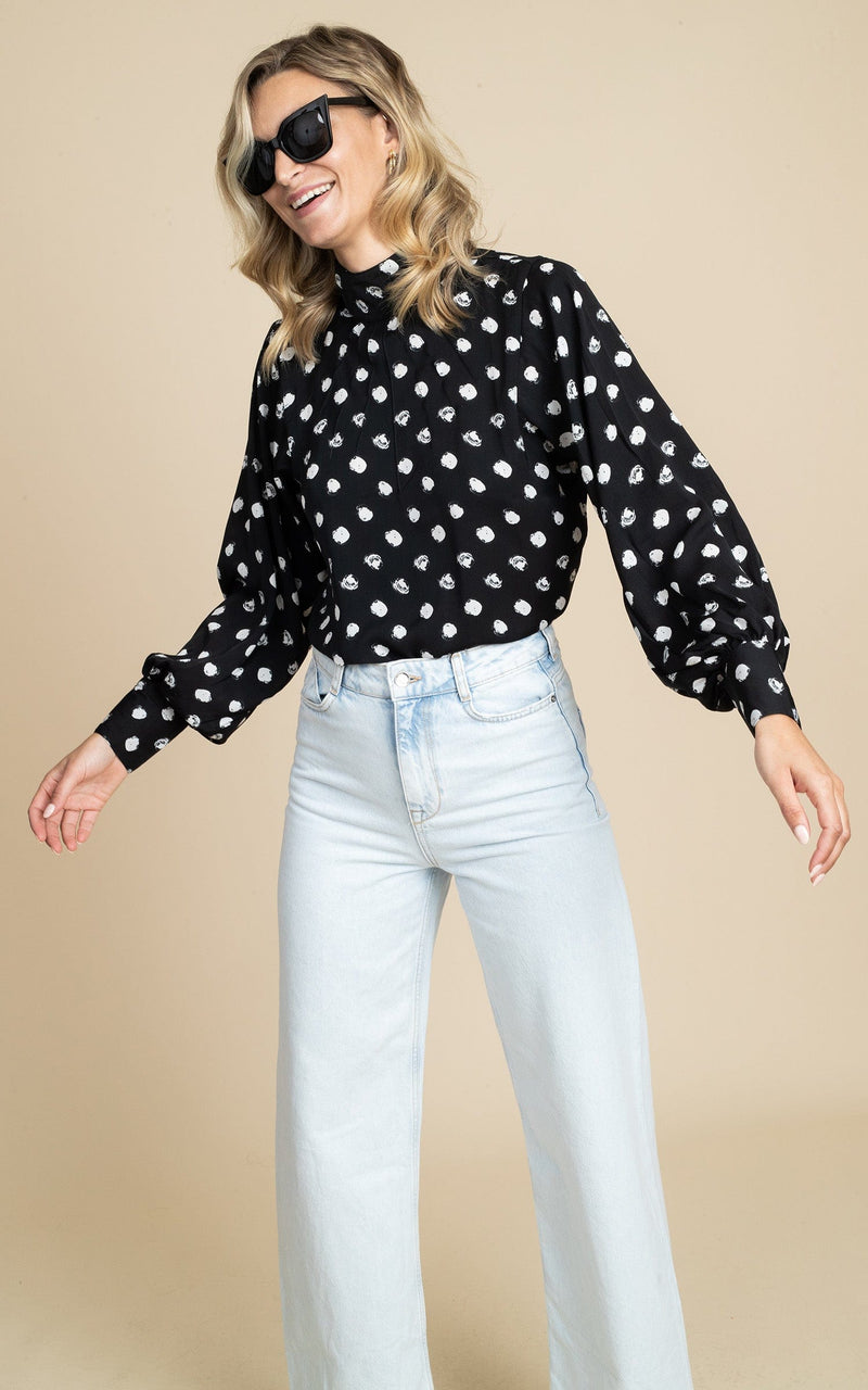 Dancing Leopard model wearing Margo Pintuck Blouse in Polka Dot with light jeans and sunglasses