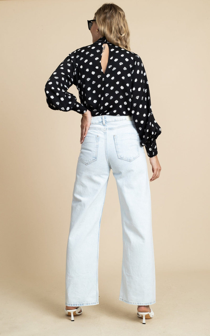 Dancing Leopard model wearing Margo Pintuck Blouse in Polka Dot facing away to show back of blouse