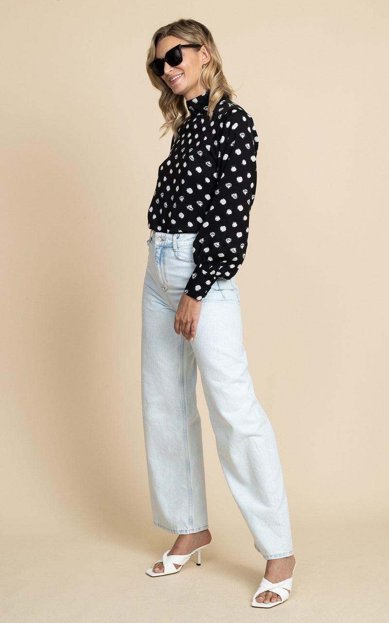 Dancing Leopard model wearing Margo Pintuck Blouse in Polka Dot facing side on