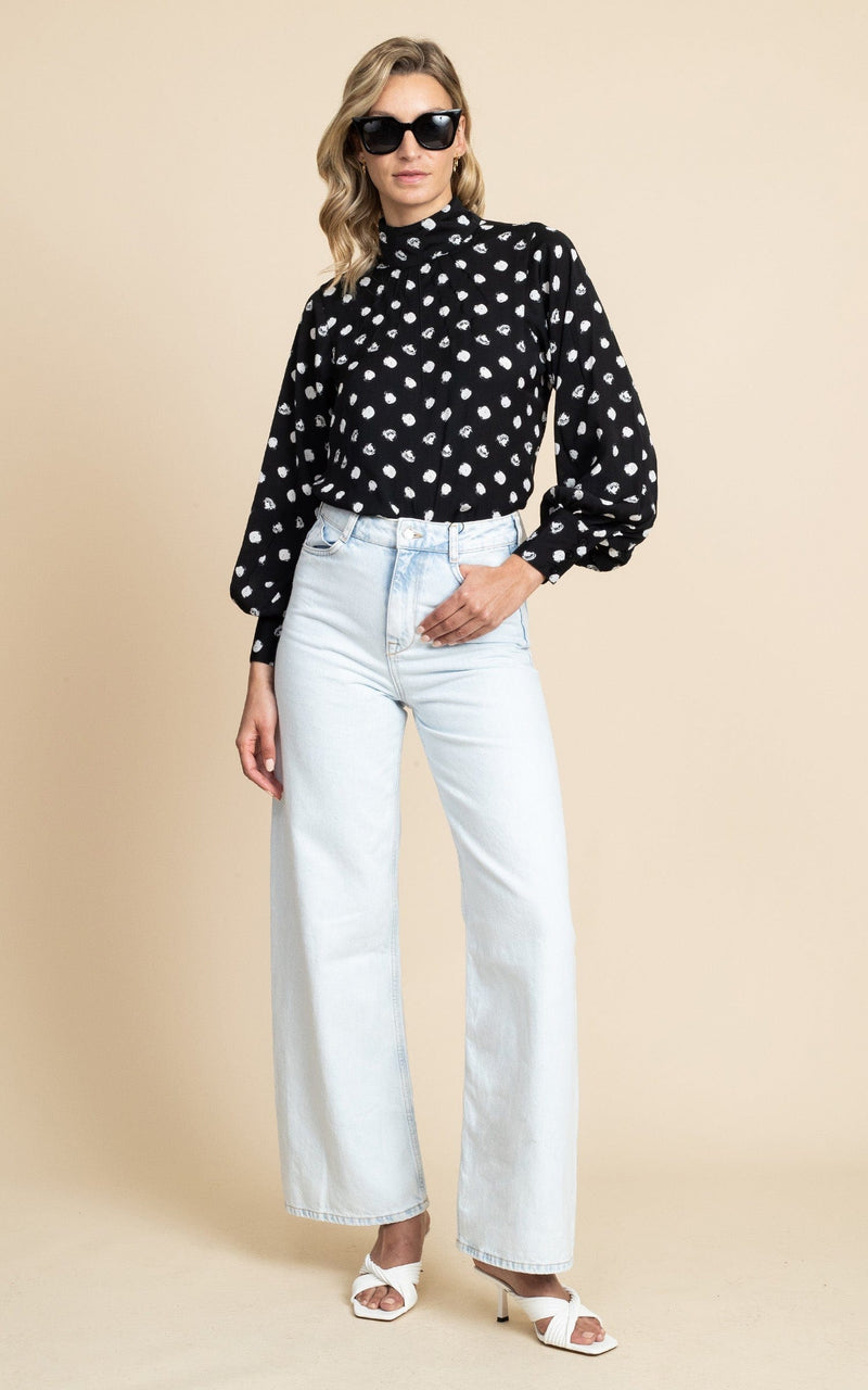 Dancing Leopard model wearing Margo Pintuck Blouse in Polka Dot with light wash jeans and sunglasses