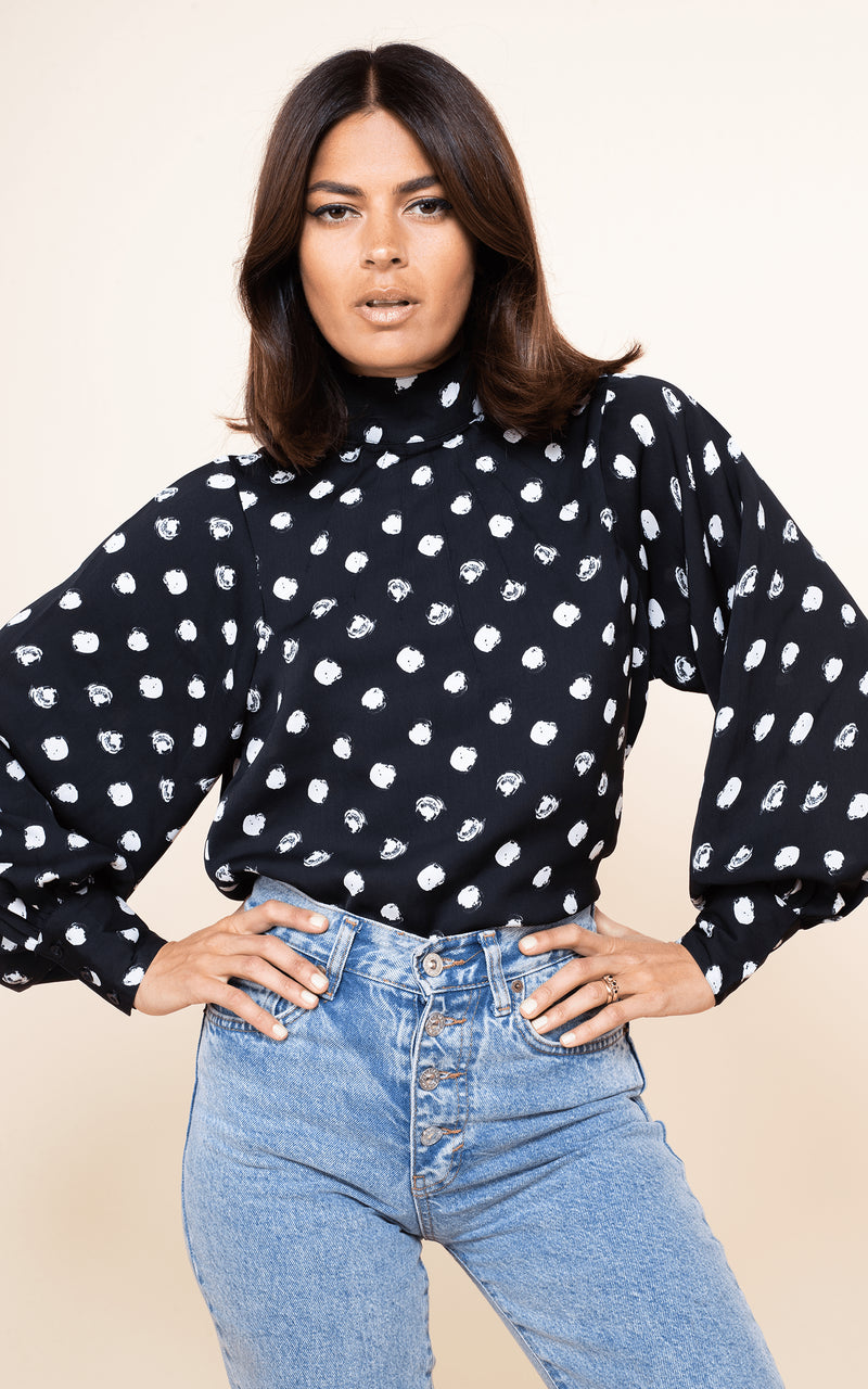 Dancing Leopard model faces forwards wearing Margo Blouse in Painted Dot with jeans