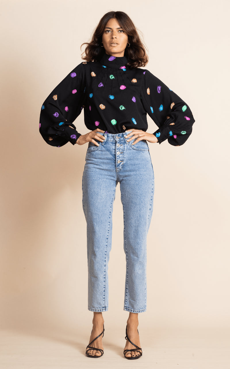 Dancing Leopard model faces forwards with hands on hips wearing Margo Blouse in Vintage Dots with jeans