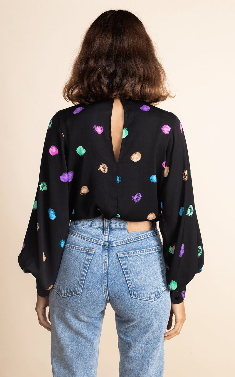 Dancing Leopard model faces backwards wearing Margo Blouse in Vintage Dots with jeans