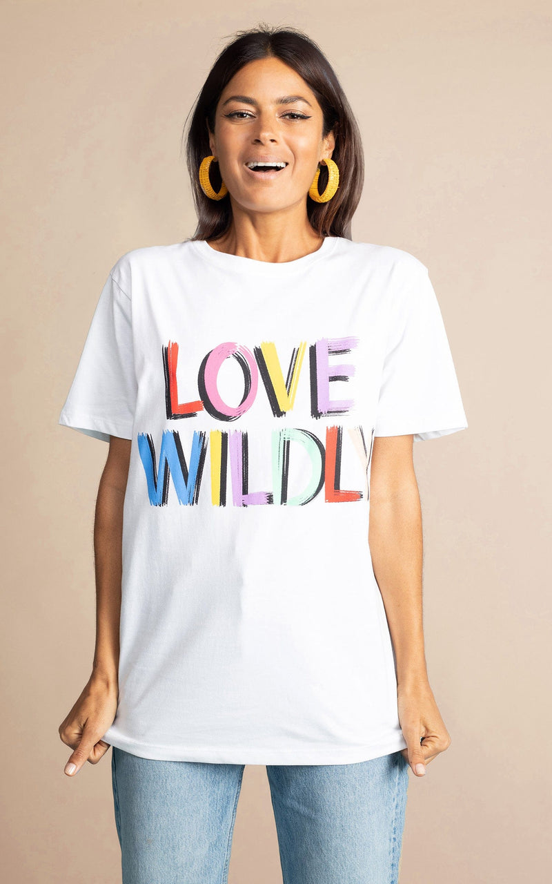 Dancing Leopard model wearing untucked Love Wildly charity white t-short for Shelter with light wash blue jeans 