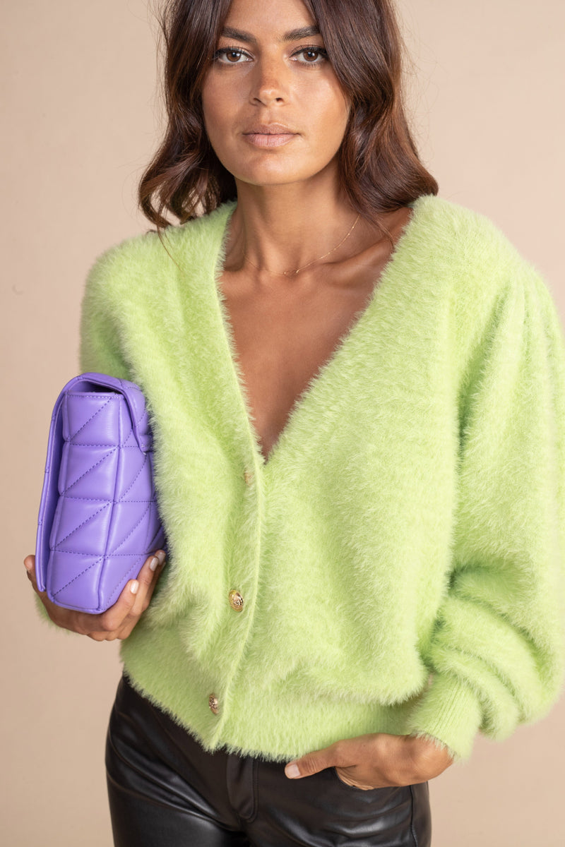 close up of Dancing Leopard model wearing Bambino Cardigan in Sherbert holding purple bag