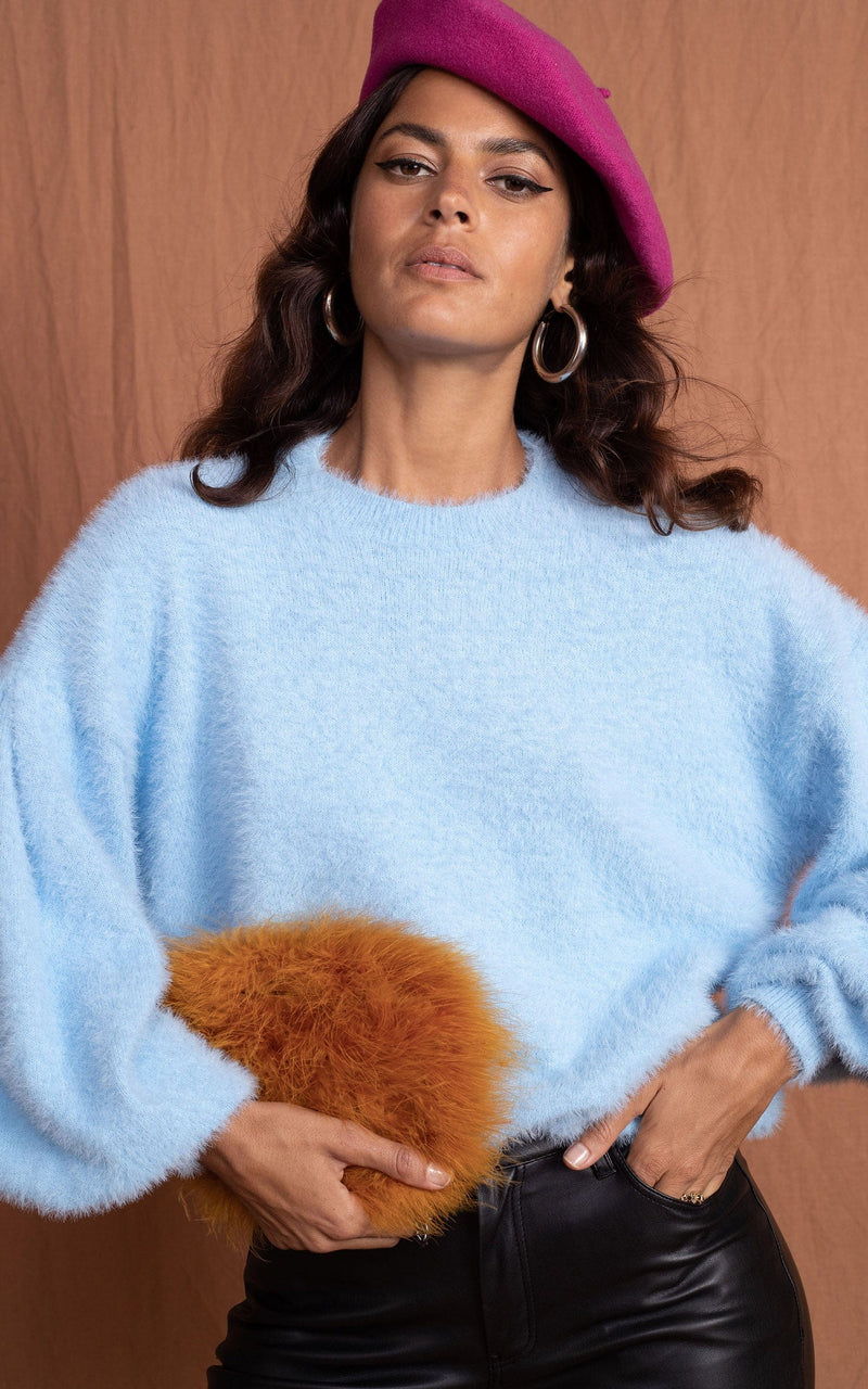 close up of Dancing Leopard model wearing Honey Jumper in Baby Blue with pink beret and brown fluffy bag