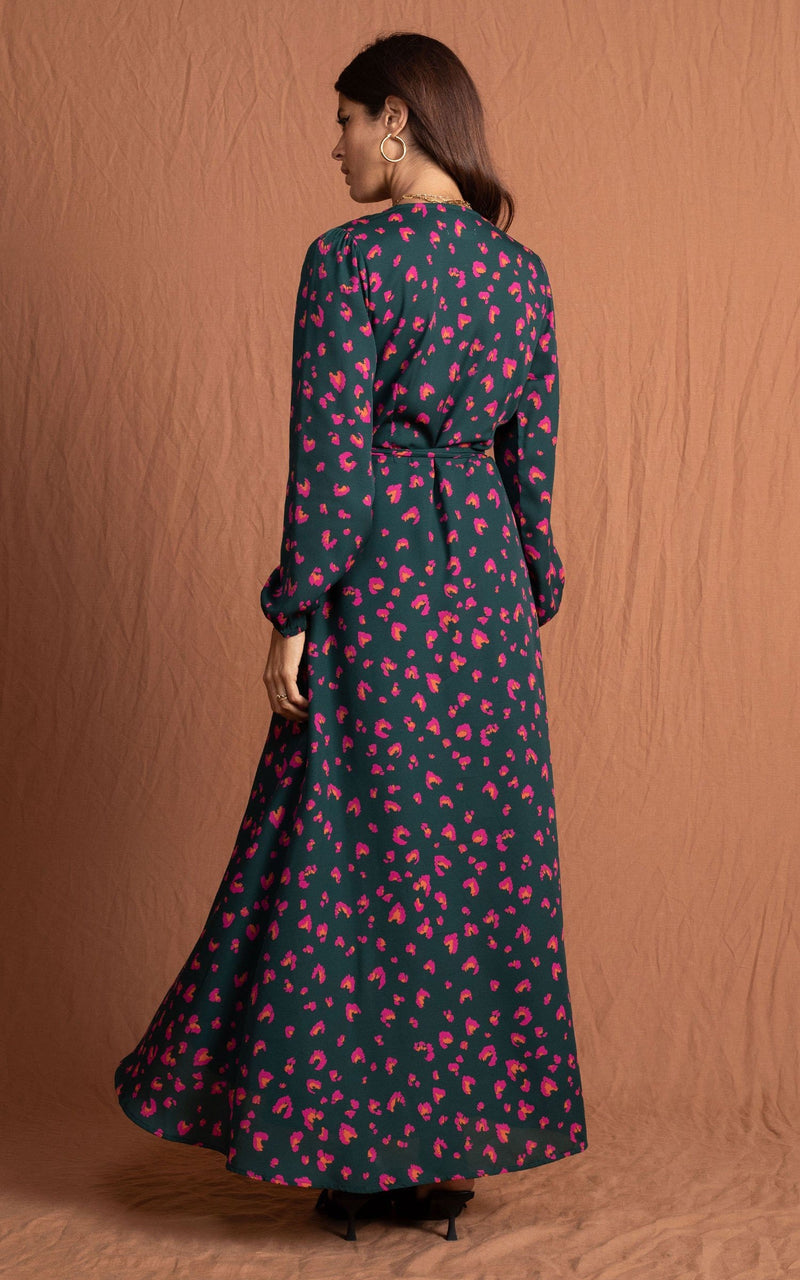 Dancing leopard model standing with back to the camera wearing jagger maxi dress in abstract pink on green