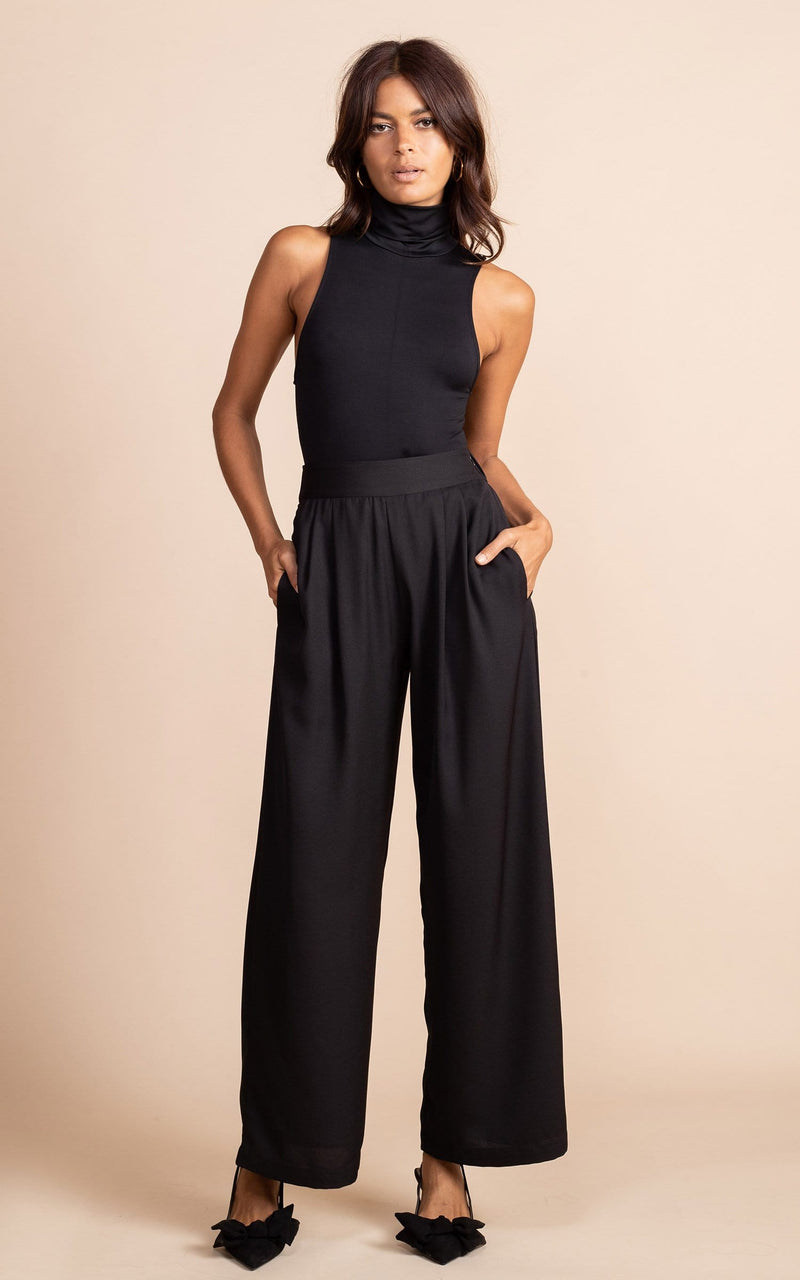 Dancing Leopard model wearing Joey Palazzo Trousers in Black posed with hands in pockets