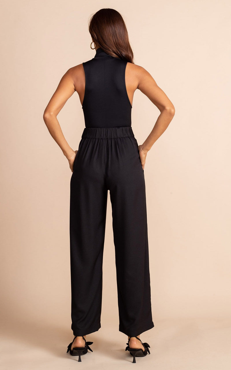Dancing Leopard model wearing Joey Palazzo Trousers in Black facing away to show back of trousers