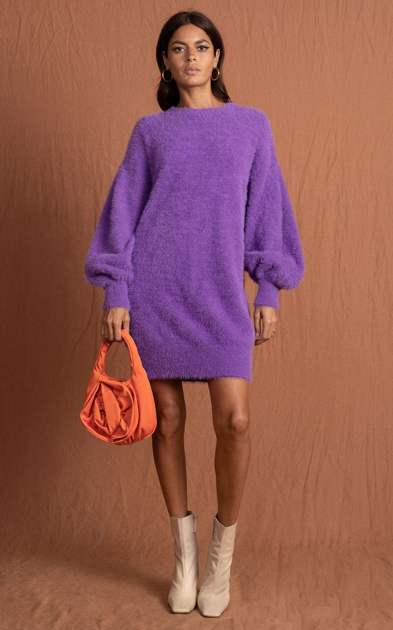 Dancing Leopard model wearing Maggie Jumper Dress in Indigo holding orange bag