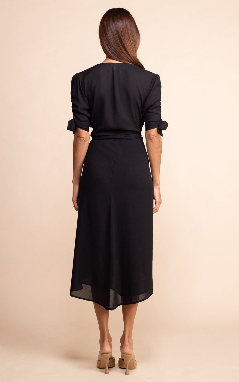 Dancing Leopard model wearing Olivera Dress In Black facing away to show back of dress