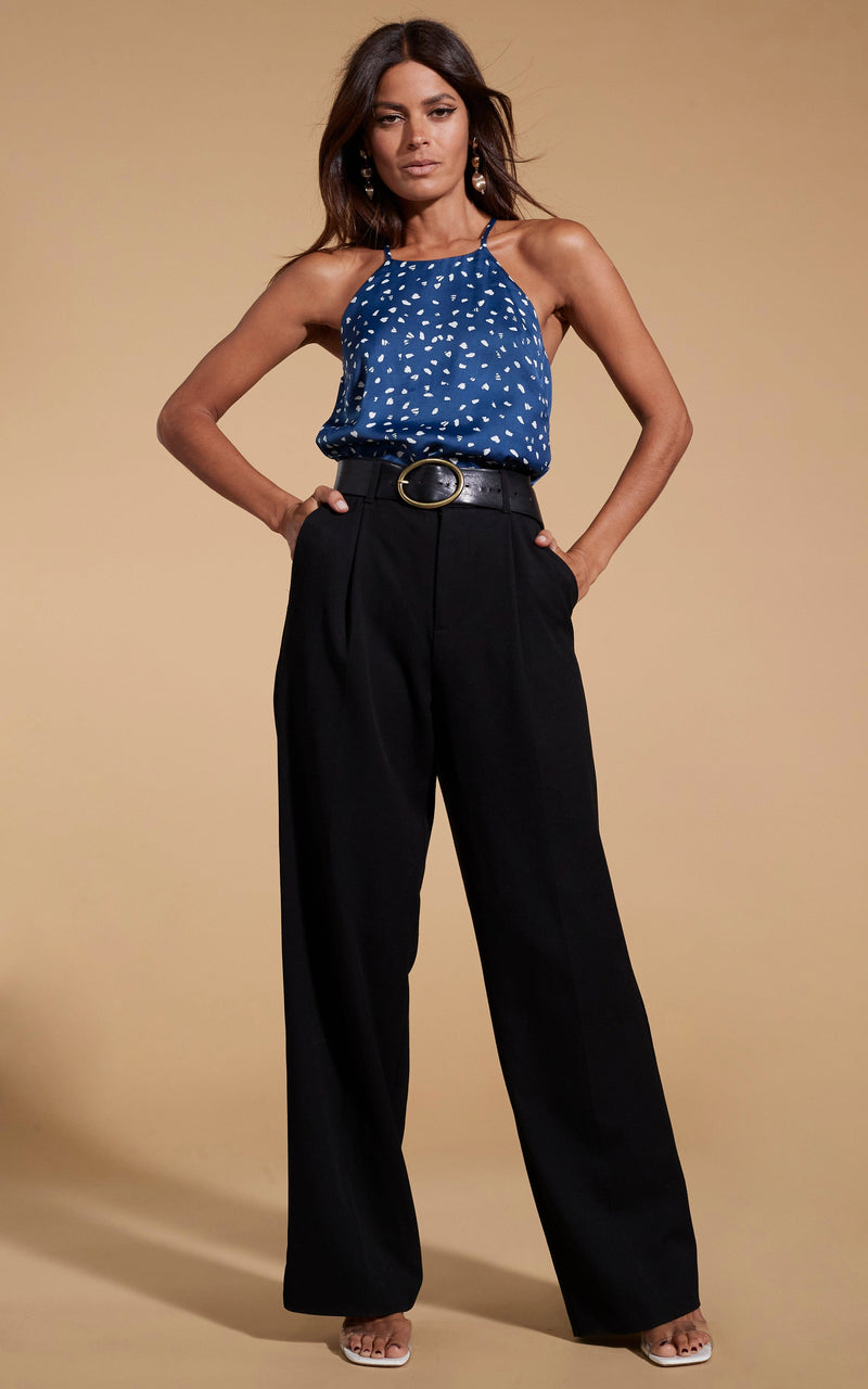 Dancing Leopard model standing with hands in wide leg black trouser pockets with Nina halter cami top abstract white on navy