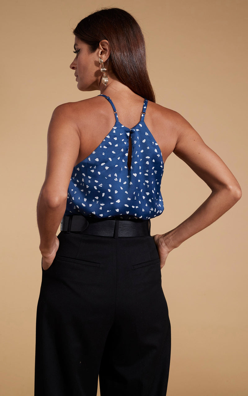 Dancing Leopard model standing with back ti the camera wearing black trousers and Nina halter cami top in abstract white on navy 
