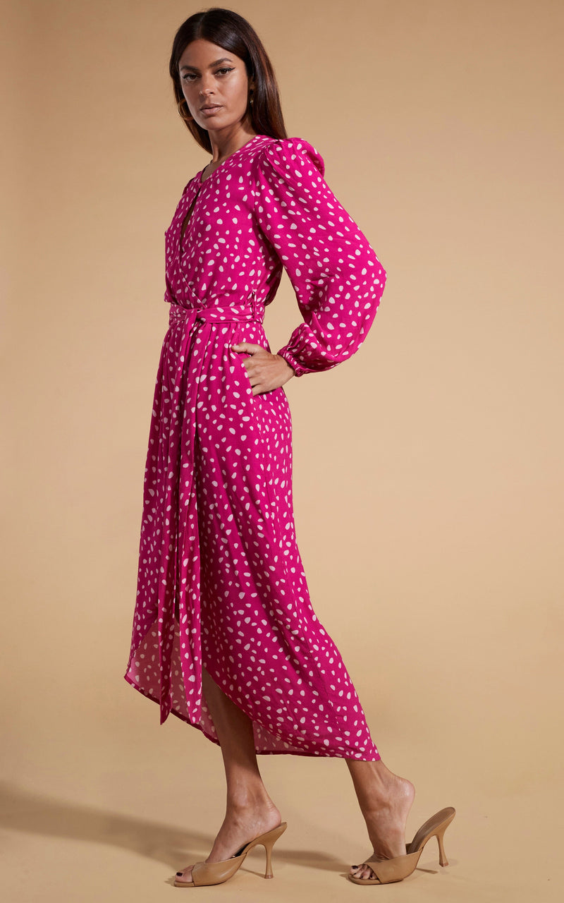 Dancing Leopard model wearing Mabel Midaxi Mock Wrap Dress in Odd Dot Pink on Magenta facing side on with hand in pocket