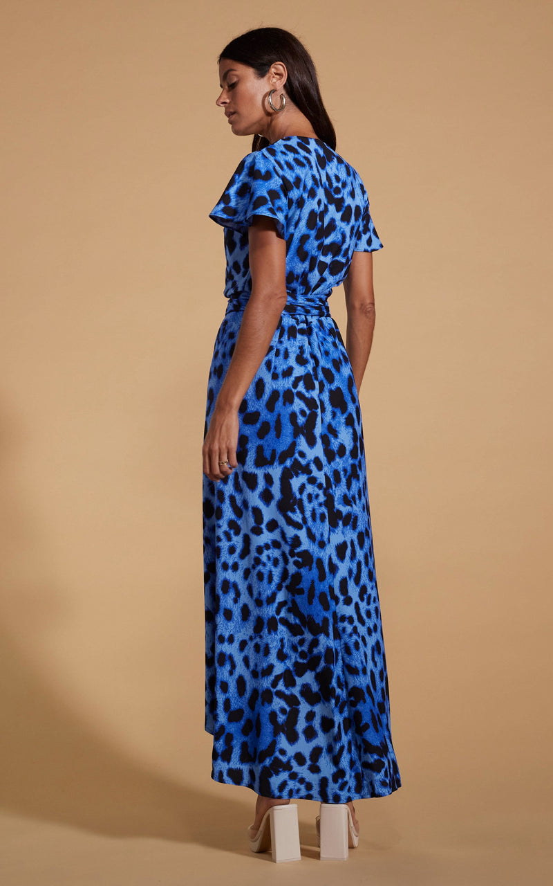 Dancing Leopard model wearing Cayenne Wrap Dress in Bright Blue Leopard facing away to reveal back details