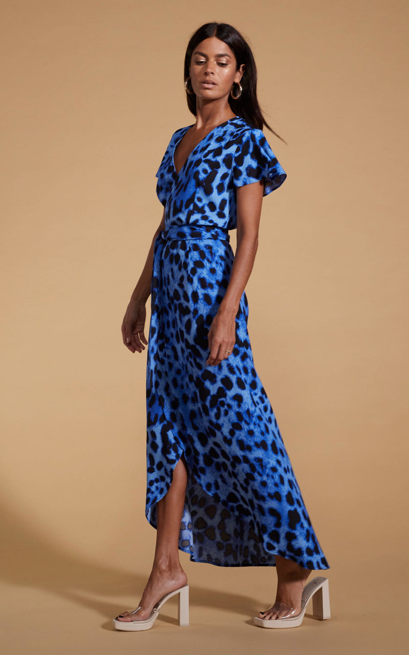 Dancing Leopard model wearing Cayenne Wrap Dress in Bright Blue Leopard walking right to left