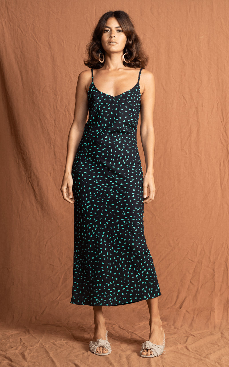 Dancing Leopard model faces forward wearing Sienna Dress in green on black print and sandals