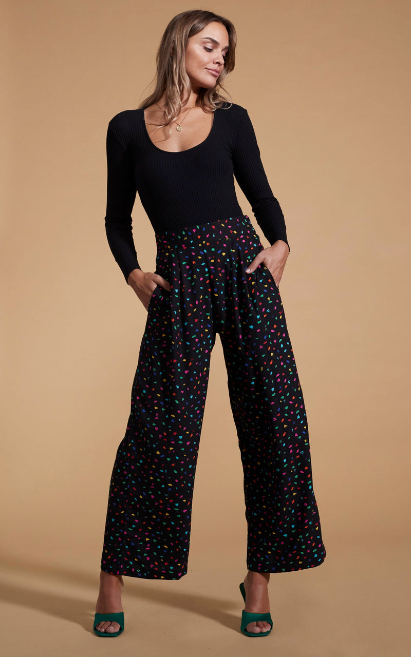 Dancing Leopard model wearing Joey Palazzo Trousers in Abstract Multi posed with hands in pockets