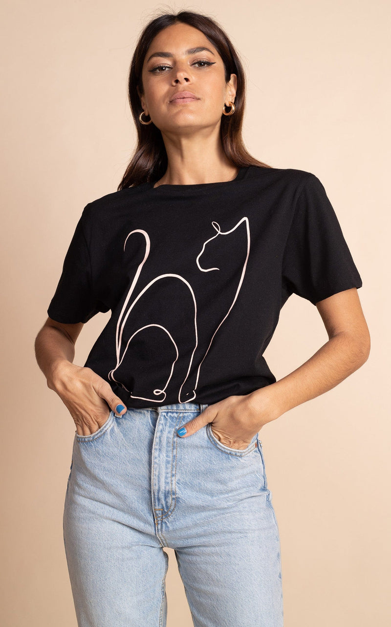 Close up of Dancing Leopard model standing face forwards with hands in pockets wearing black cat charity T-shirt with blue denim jeans