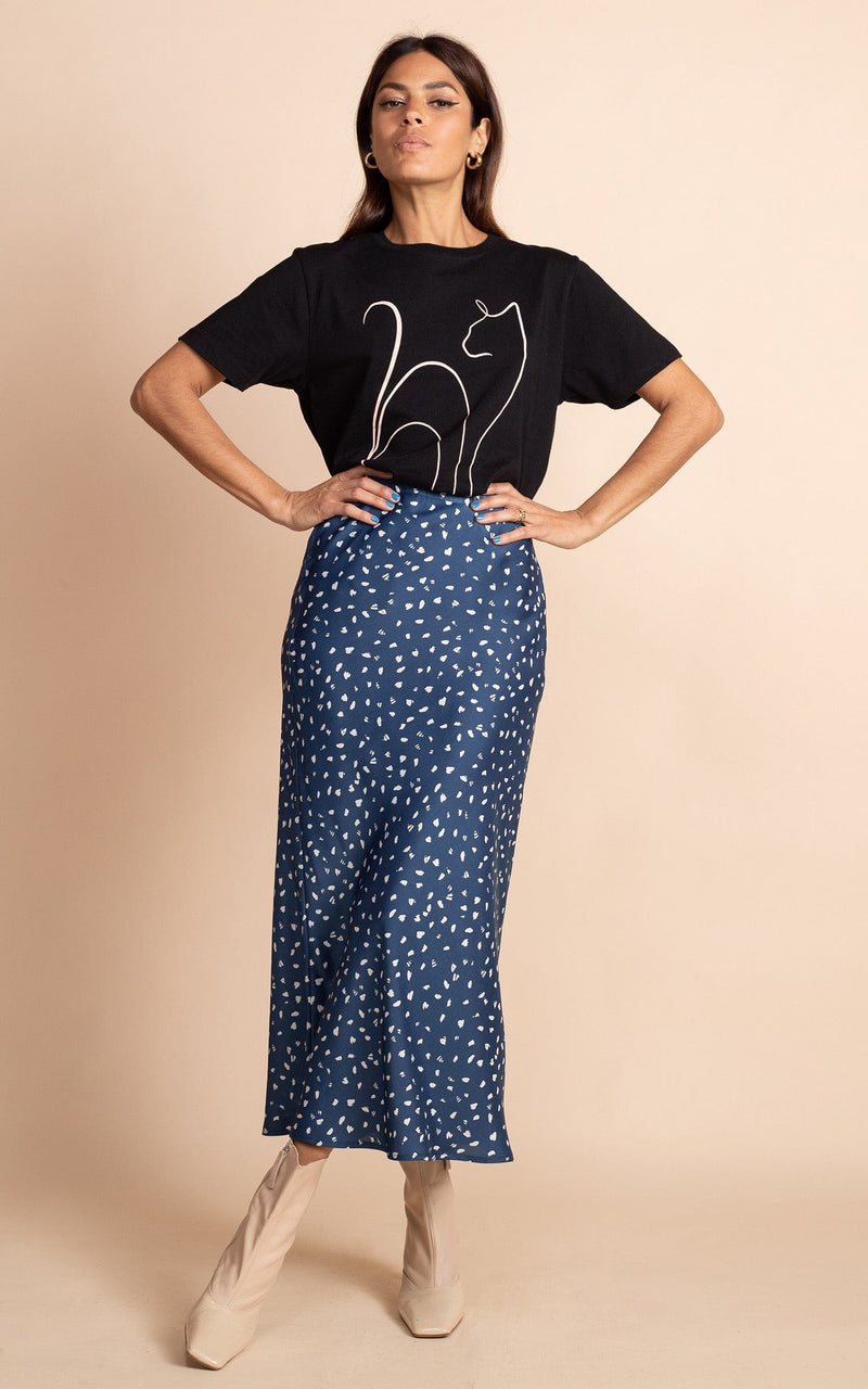 Dancing Leopard model standing forwards with hands on hips wearing blue navy and white with black cat t-shirt and cream boots